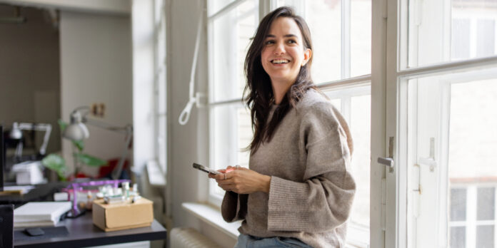 frau-buero-handy-lachen_iStock-2209182524_1500x750
