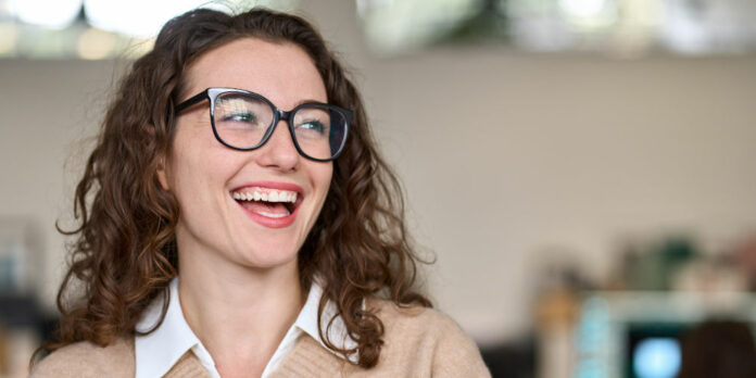 frau-jung-lachen-arbeitsumfeld_iStock-1442442050