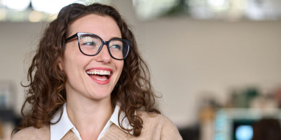 frau-jung-lachen-arbeitsumfeld_iStock-1442442050