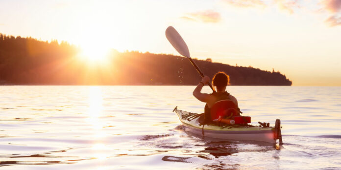 frau-kajak-meer-sonne_iStock-1301430955