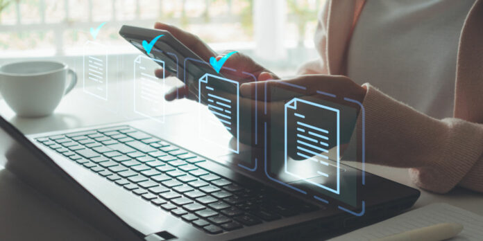 frau-smartphone-laptop-dokumente_iStock-2170426739