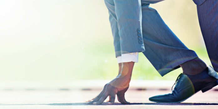 A businessman on a track ready to run