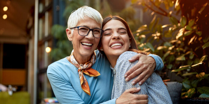 mutter-tochter-erwachsen-umarmung-lachen_iStock-1309443971